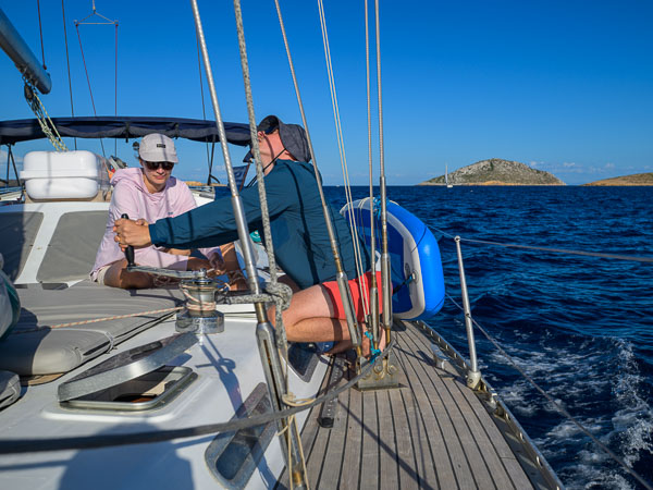 Passengers helping out on deck during their sailing holiday on Artemis in Greece